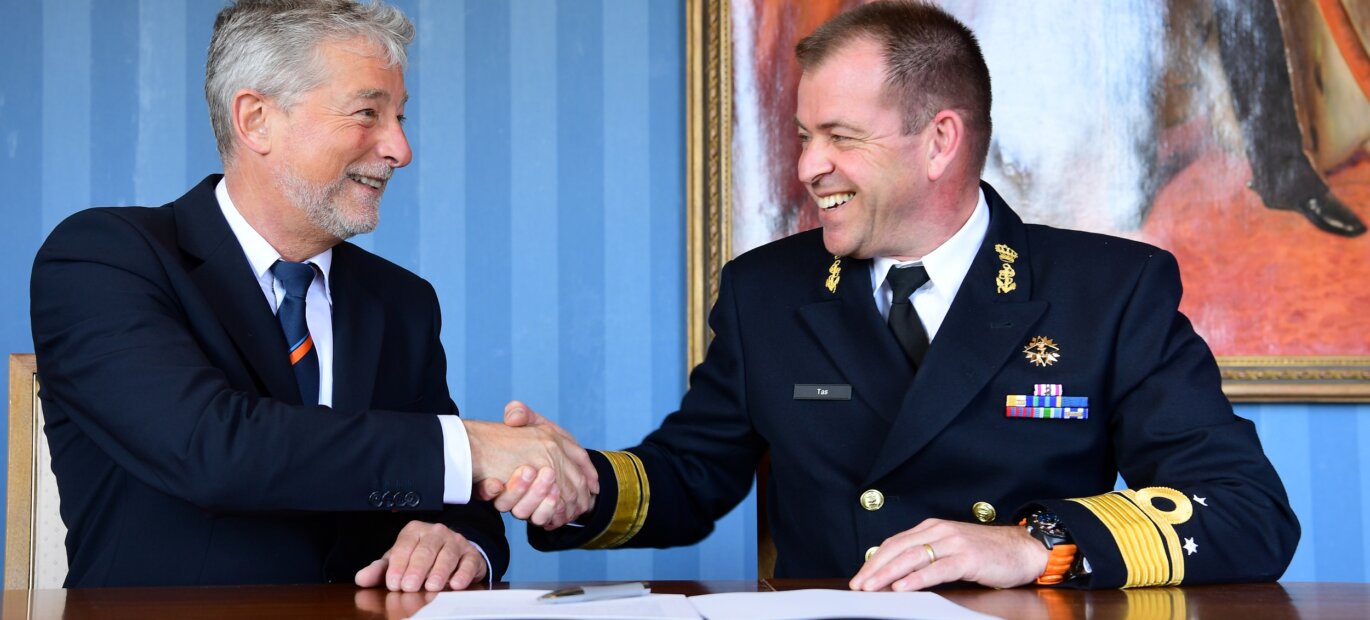 Directeur Kustwacht Nederland Jan van Zanten en Commandant Zeestrijdkrachten vice-admiraal René Tas schudden elkaar de hand.