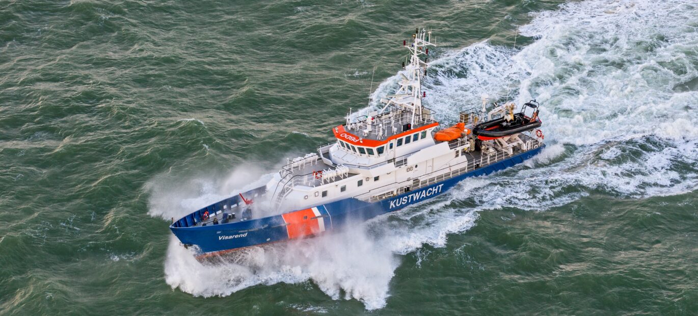 Patrouillevaartuig Visarend vaart met hoge snelheid op zee.
