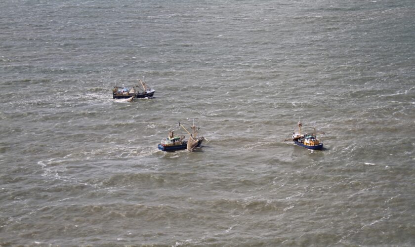 Drie vissersschepen zijn op zee gefotografeerd vanuit het Kustwachtvliegtuig. Aerial officers aan boord van het Kustwachtvliegtuig houden toezicht op de naleving van regels voor de visserij.