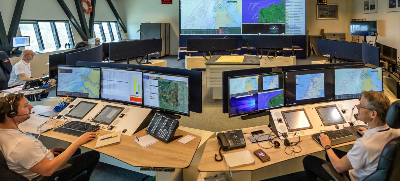 Op het Kustwachtcentrum staan meerdere tafels met schermen, informatie- en communicatiesystemen.