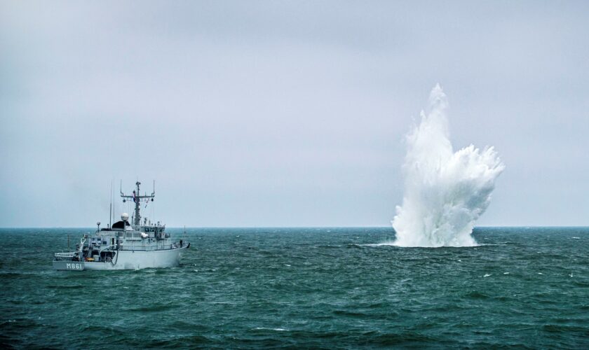 Een mijnenjager van de marine ruimt een explosief op zee. Daarbij ontstaat een grote waterzuil.