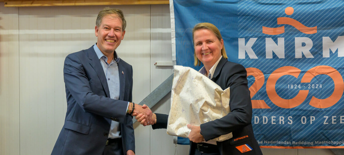 Directeur Kustwacht Nicole Kuipers overhandigt cadeau aan directeur KNRM Jacob Tas